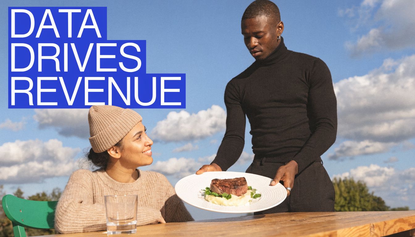 A man in a turtleneck serving a gourmet steak dish to a woman at an outdoor table.