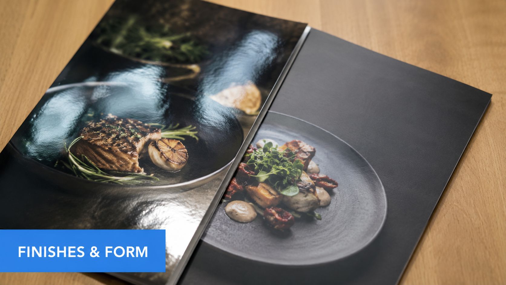 A close-up view of two printed menu cards on a wooden table, showcasing different paper finishes.